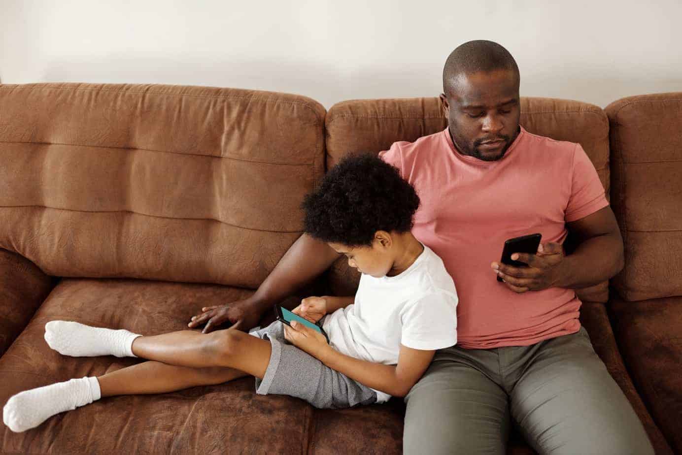 father and son relaxing on a sofa